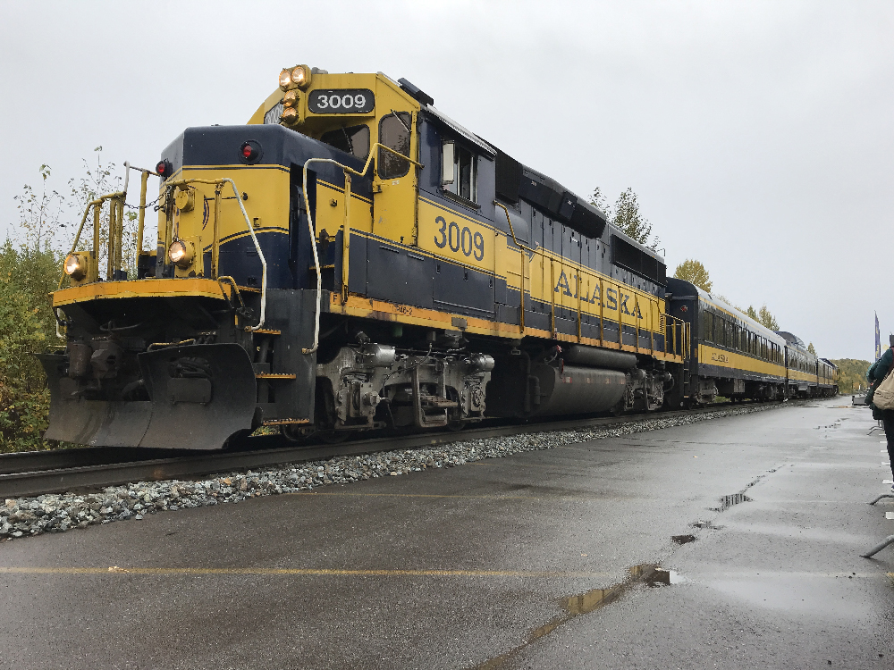 Blue and yellow diesel powered passenger train.