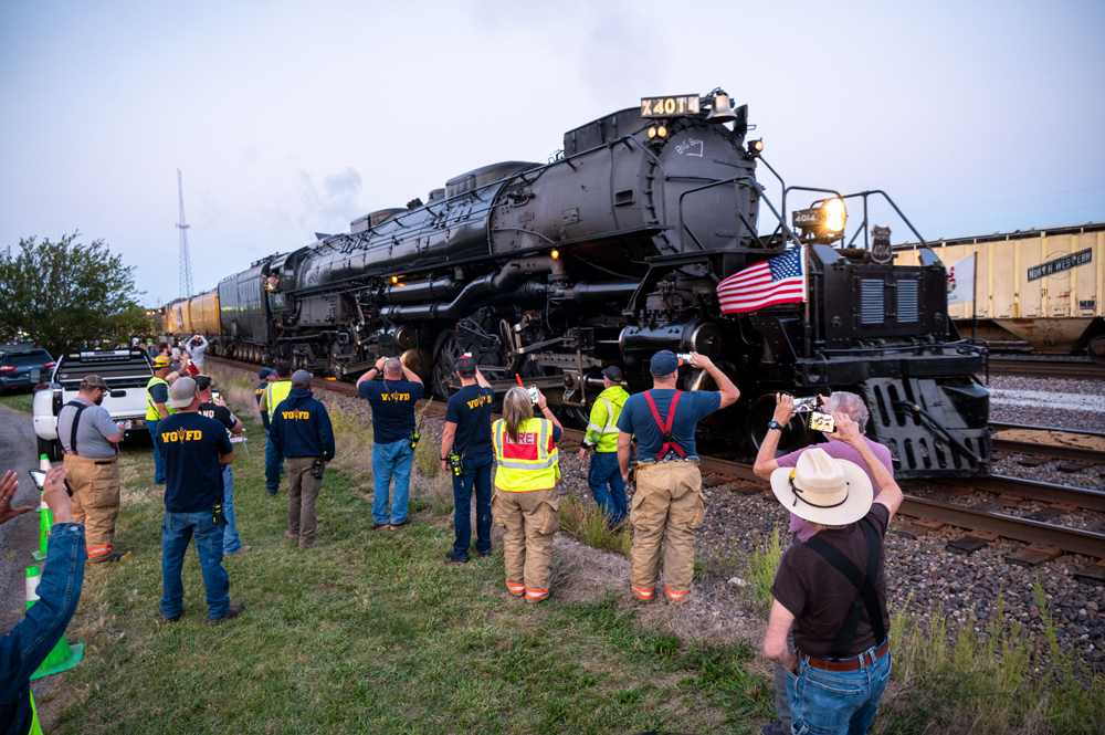 people taking photos of black steam locomotive