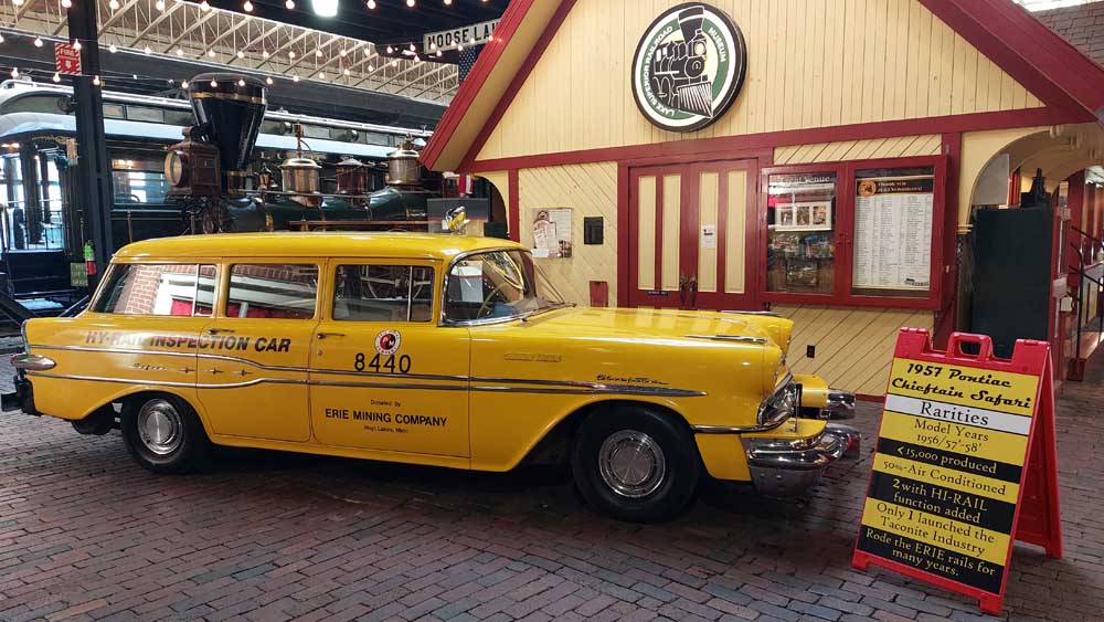 Yellow restored Erie Mining hi-rail car indoors