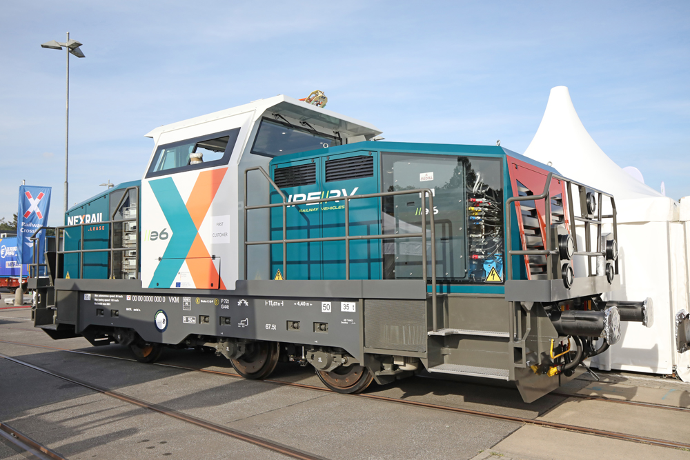 Smwall white and blue switcher with orange and blue graphics on center cab