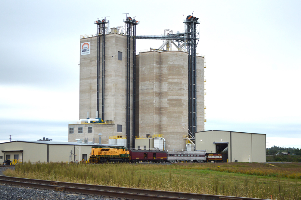 Short train passes in front of silos at new feed mill