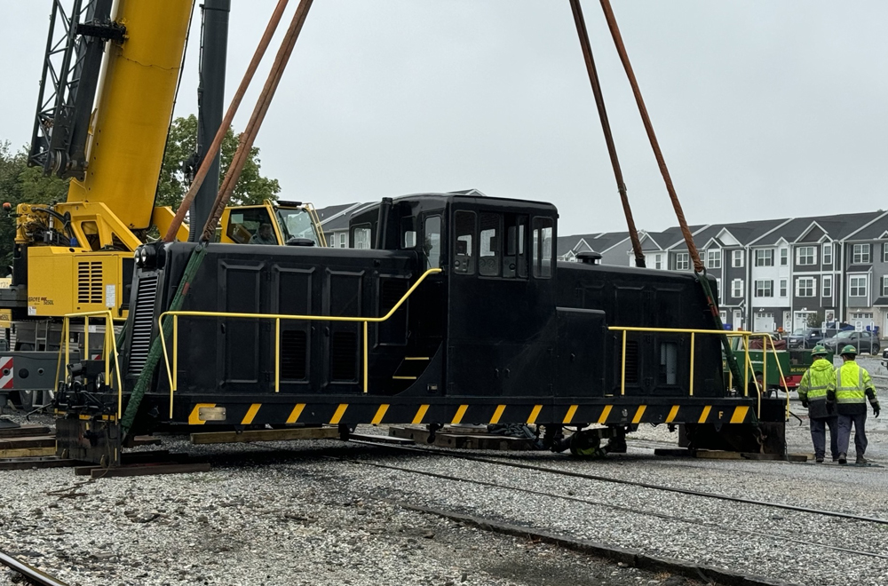 Black locomotive moved by crane