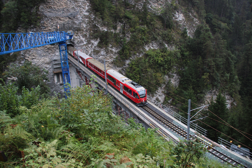 Red train on bridge under construction