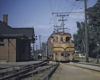 Yellow electric Illinois Terminal locomotives with train in front of brick station