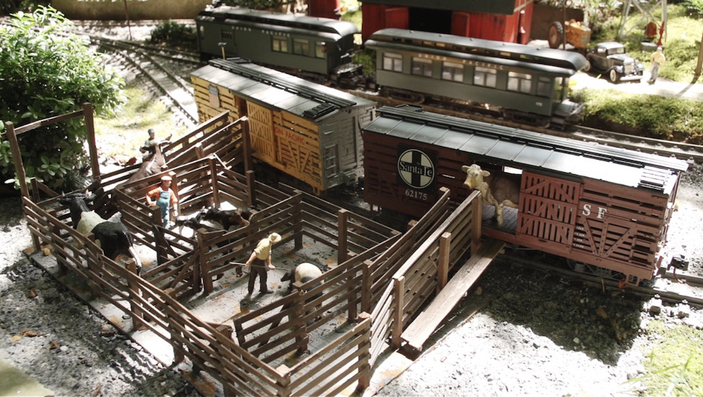 model pens with cattle and cattle cars on garden railway