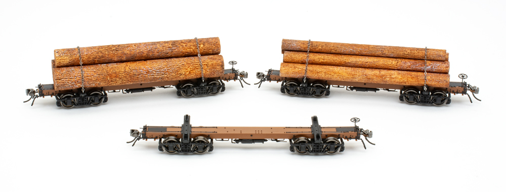 Group photo of three HO scale log cars on white background.