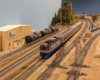 A model amtrak train in a staging and interchange yard on a model railroad layout