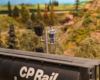 A model figure stands in an overwatch tower next to a model tank car on a model railroad layout