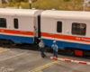 Two model police figures next to a model amtrak passenger car