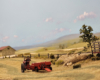 A red model tractor in a farm setting on a model railroad layout