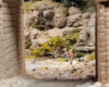 Two model figures stand with fishing poles under a bridge on a model railroad layout