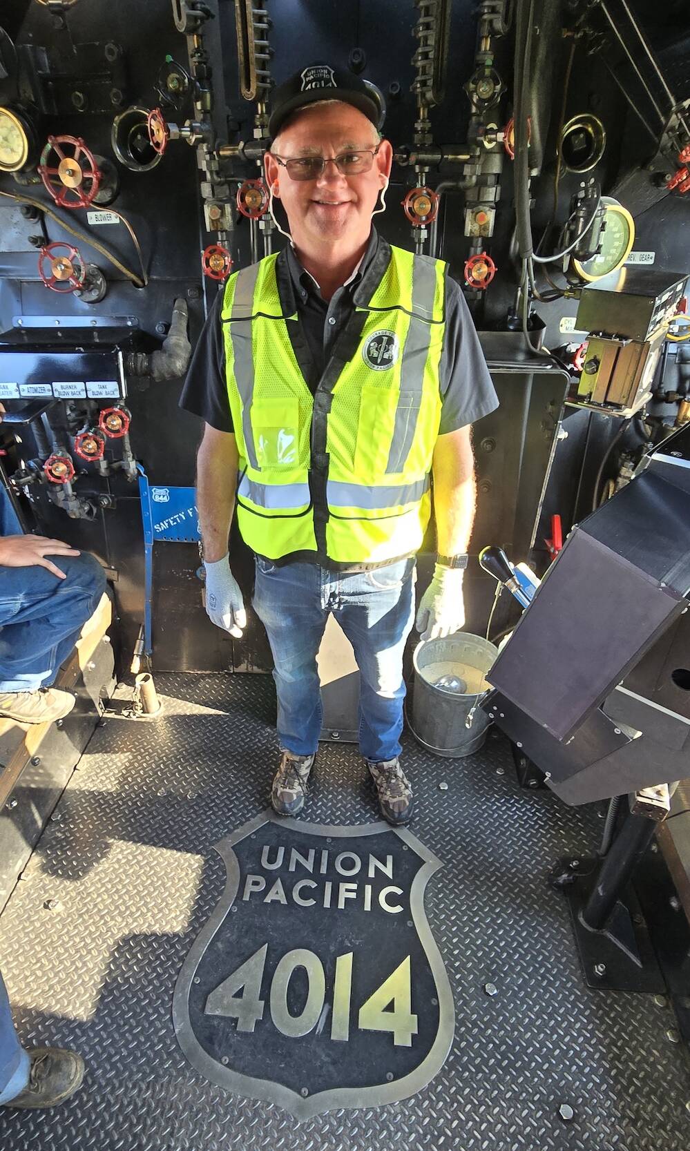 Person standing in the cab of a steam locomotive