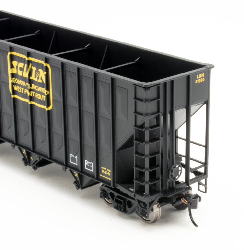 Color photo of black HO scale freight car with yellow graphics.