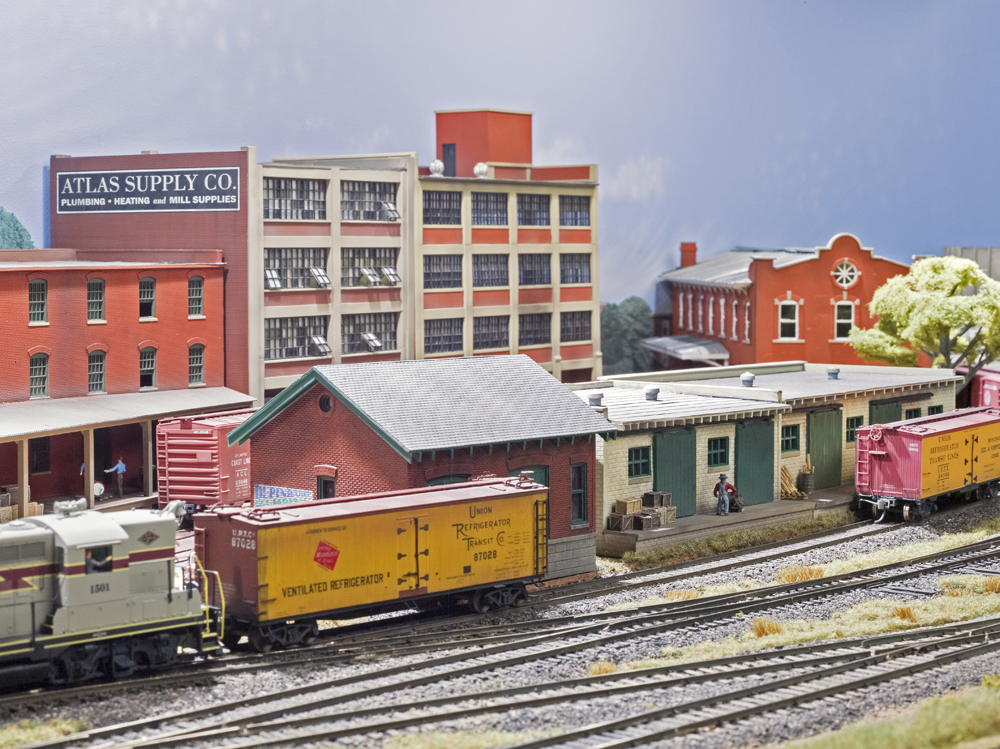 Color photo of buildings on HO scale model railroad.