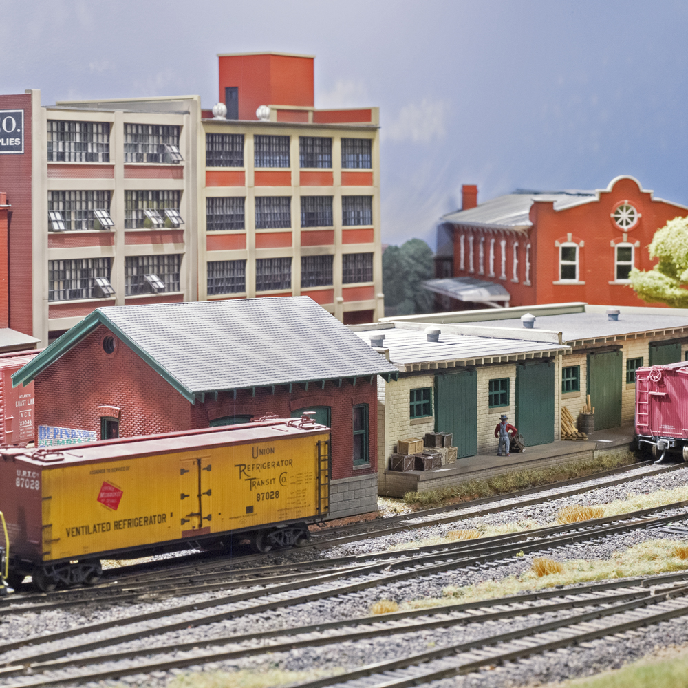 Color photo of buildings on HO scale model railroad.