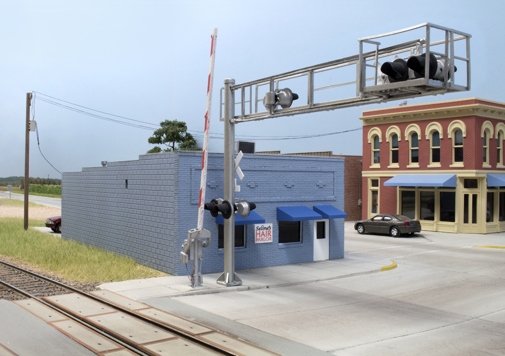 Color photo showing small-town buildings by railroad crossing.