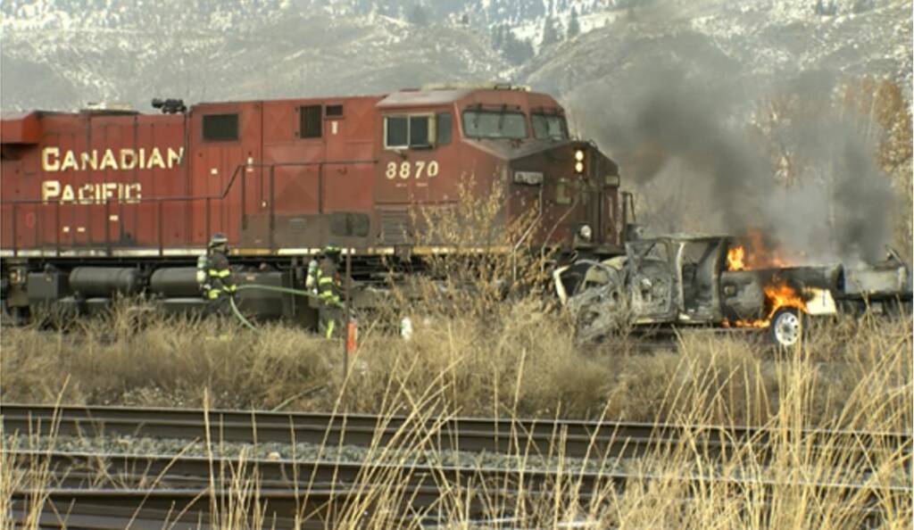 Red locomotive and burning truck