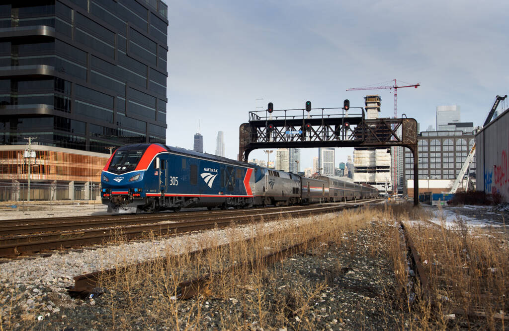 Amtrak train under bridge in city