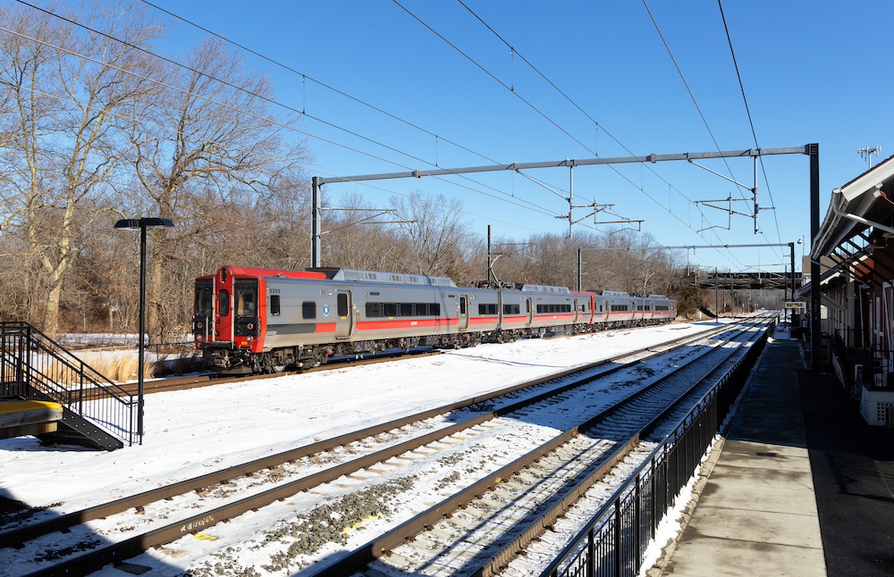 Electric train passes. by station on a clear winter day