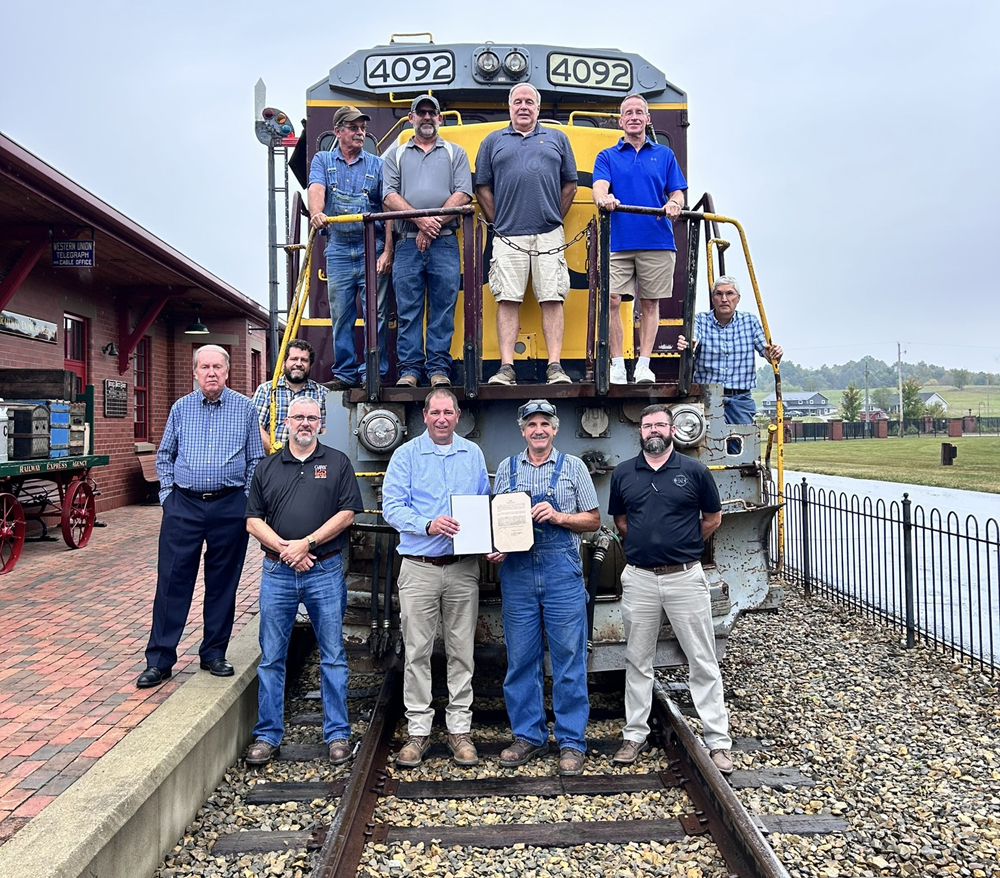 Group of people standing on or in front of diesel locomotive