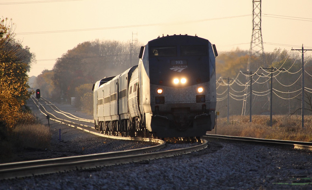 Passenger train on curve in golden-hour lighting