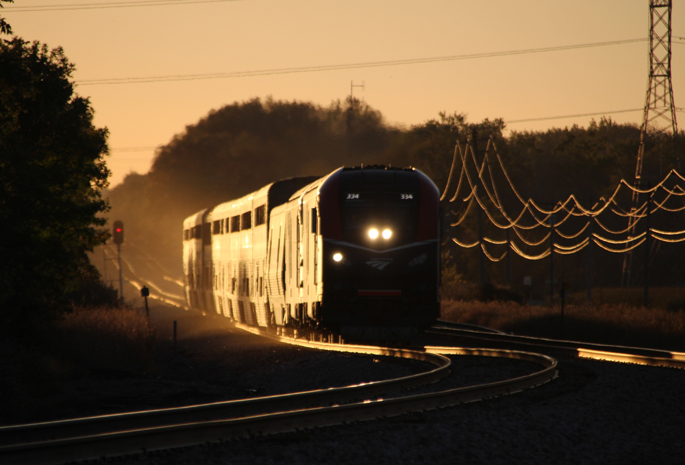 Train kicking up dust near sunset