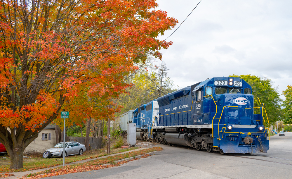 Freshly painted blue diesel next to tree in full fall colors