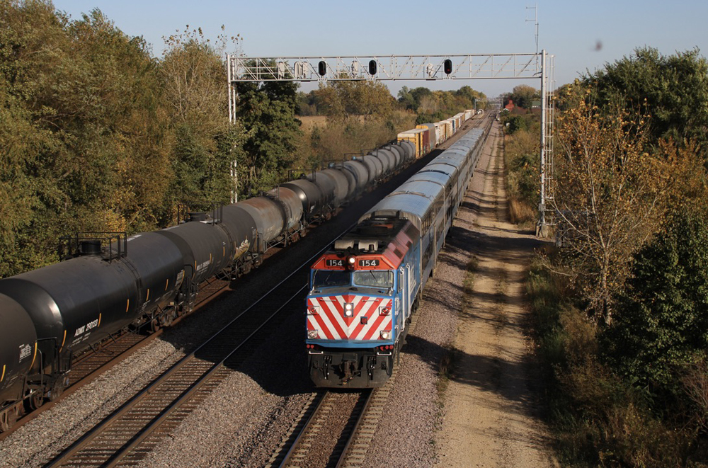 Commuter train passes under signal bridge