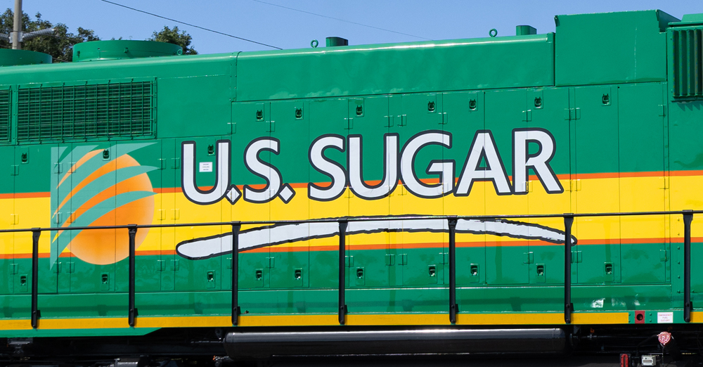 Logo of U.S. Sugar as seen on side of green and yellow locomotive