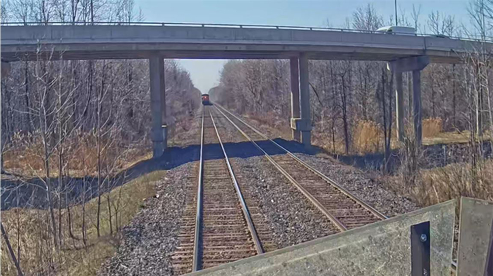 Image of freight train as seen from cab of passenger train on same track.