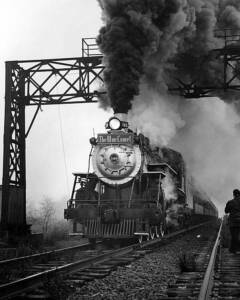 Heavily smoking U.S. Sugar 148 steam locomotive under signal bridge