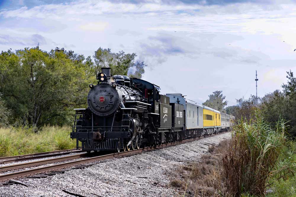 Steam locomotive with mixed passenger train consist on straight track