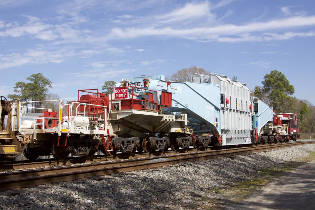 red and white railroad car on track