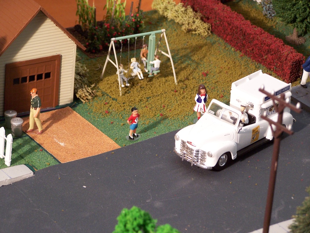 model ice cream truck with figures and house in the background