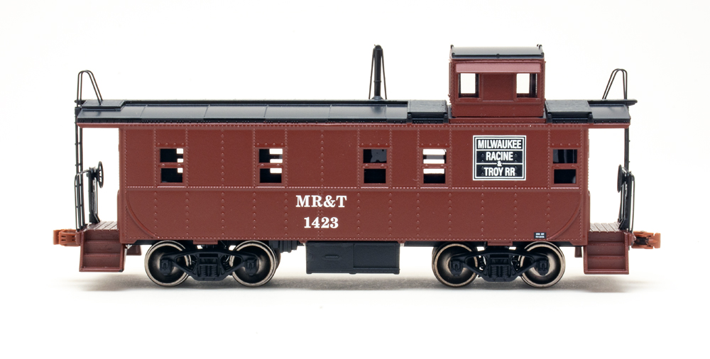 Side view of HO caboose painted brown and black.