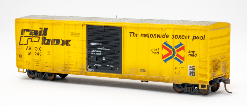 Color photo of HO scale boxcar painted yellow on white background.