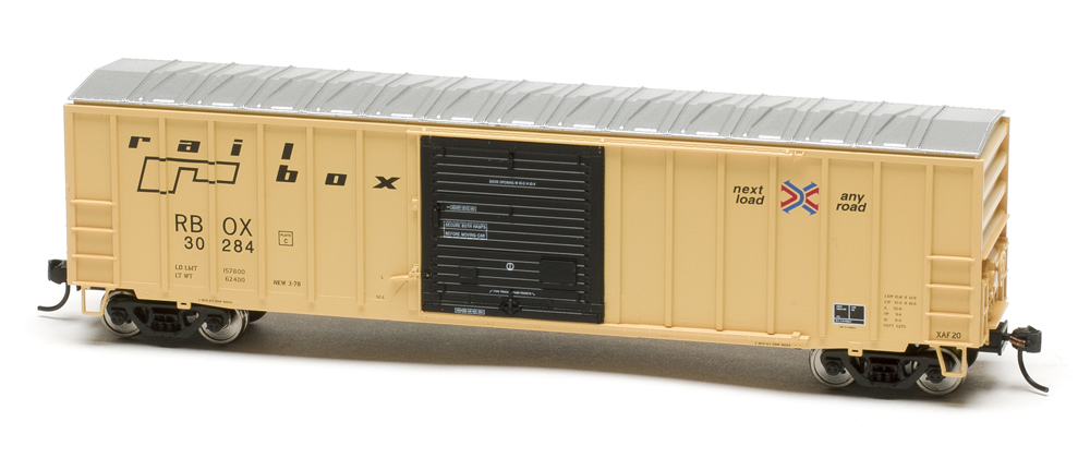 Color photo of HO scale boxcar painted yellow with black door and aluminum roof.