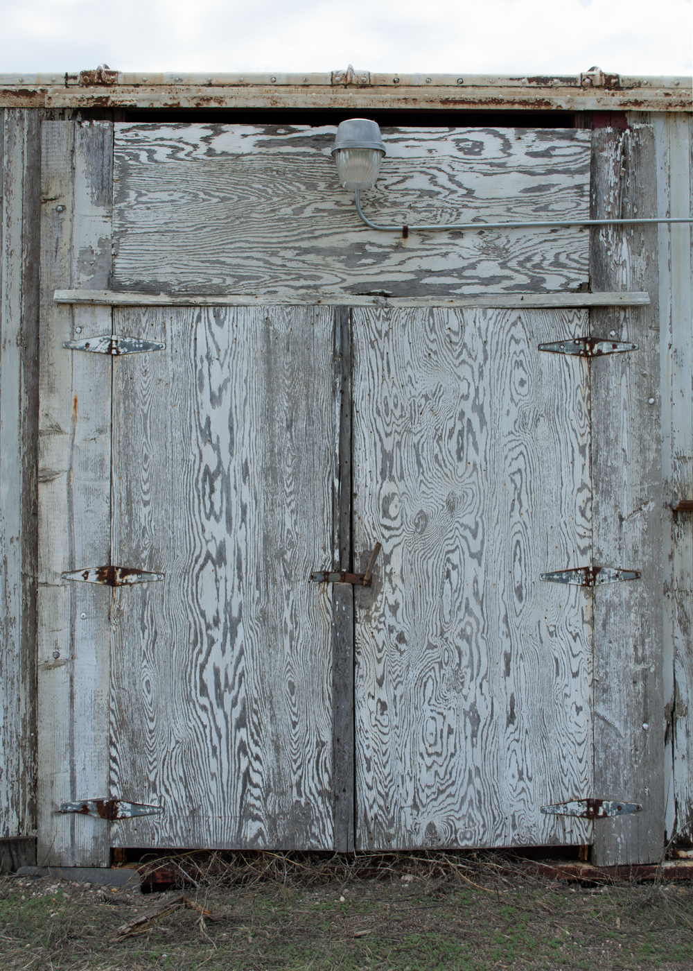 Color image showing plywood doors and light on boxcar.