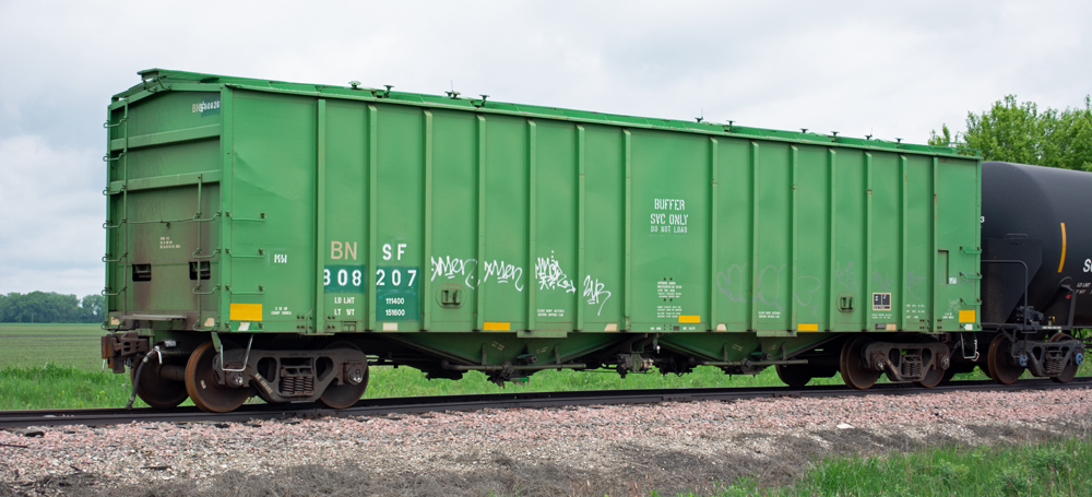 Color photo of green covered hopper with white lettering.