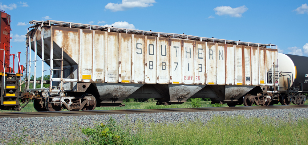 Color photo of gray covered hopper with rust streaks.