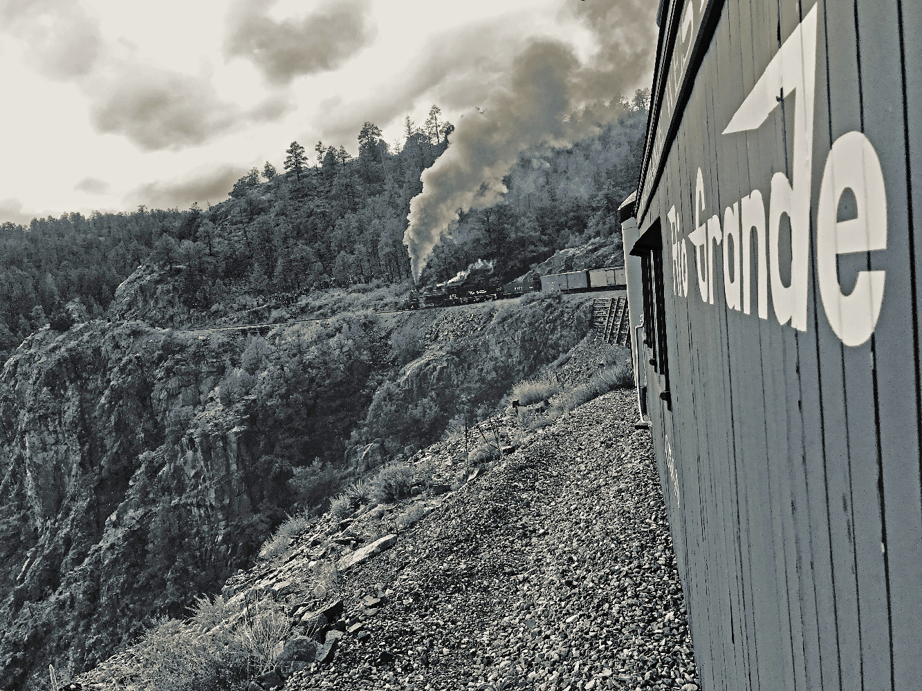 Black & white view of steam-powered train from caboose. Durango & Silverton Narrow Gauge