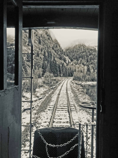 Black & white photo looking down tracks from the rear of a caboose.