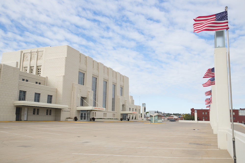 Exterior of historic railroad terminal with a lineup of flags