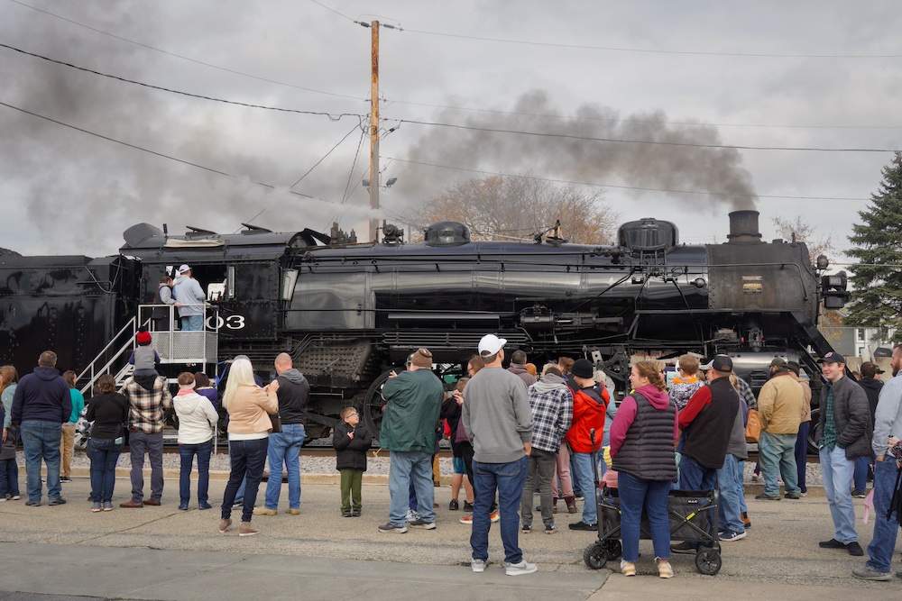 Steam locomotive in front of crowds of people