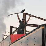 Young individual standing on top of a steam locomotive tender