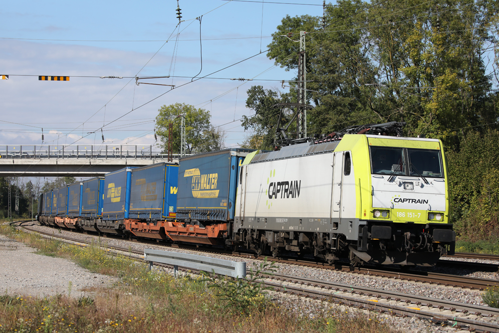 White and yellow electric locomotive with container train