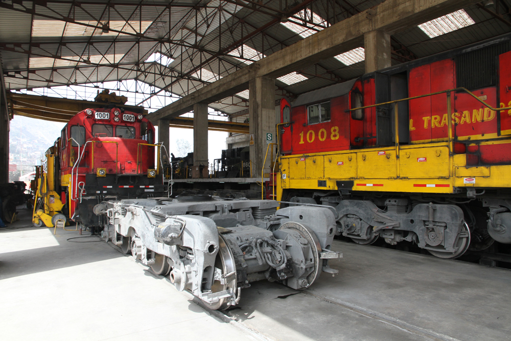 Two red and yellow locomotives in shop building