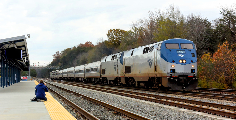 Passenger train with two silver and blue locomotives