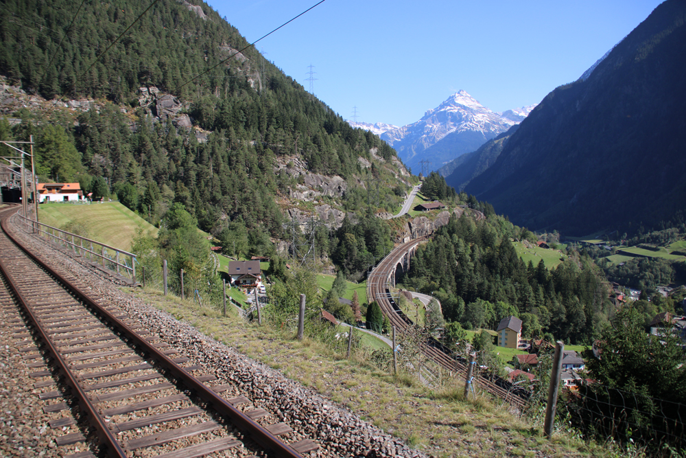 View of mountain pass with railroad tracks in foreground and below