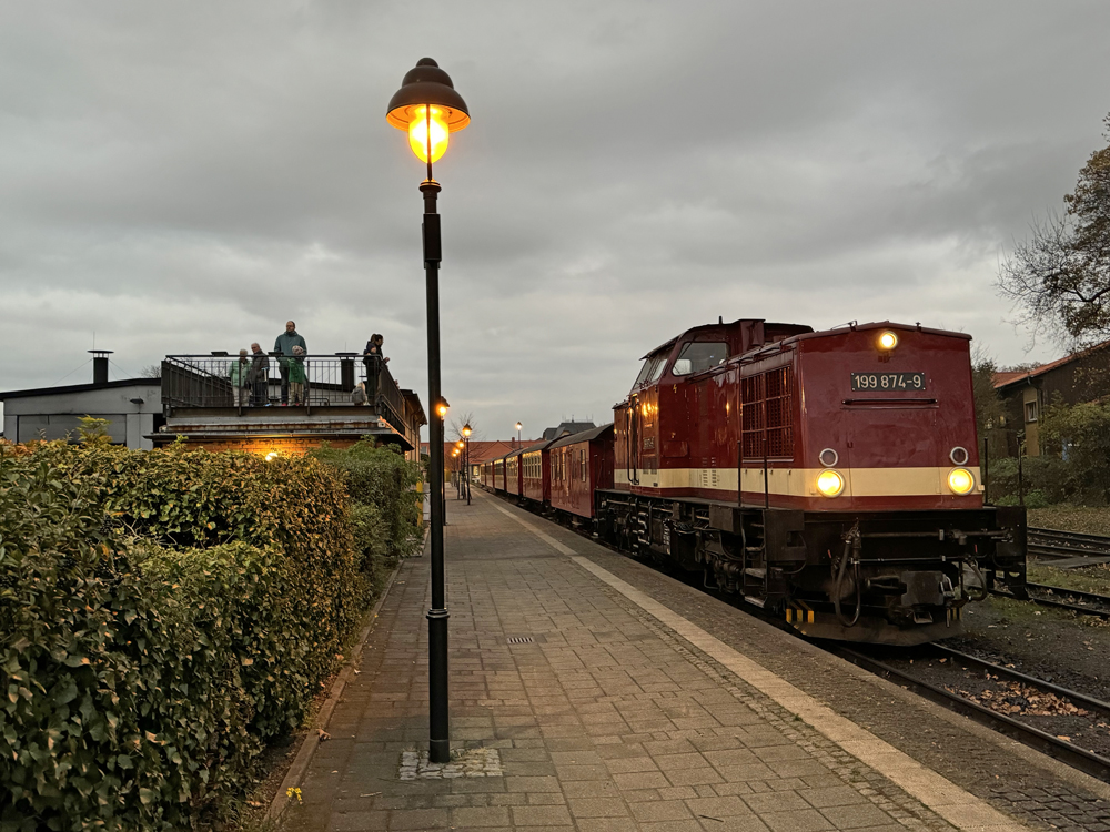 Maroon diesel on train at dusk under cloudy skies